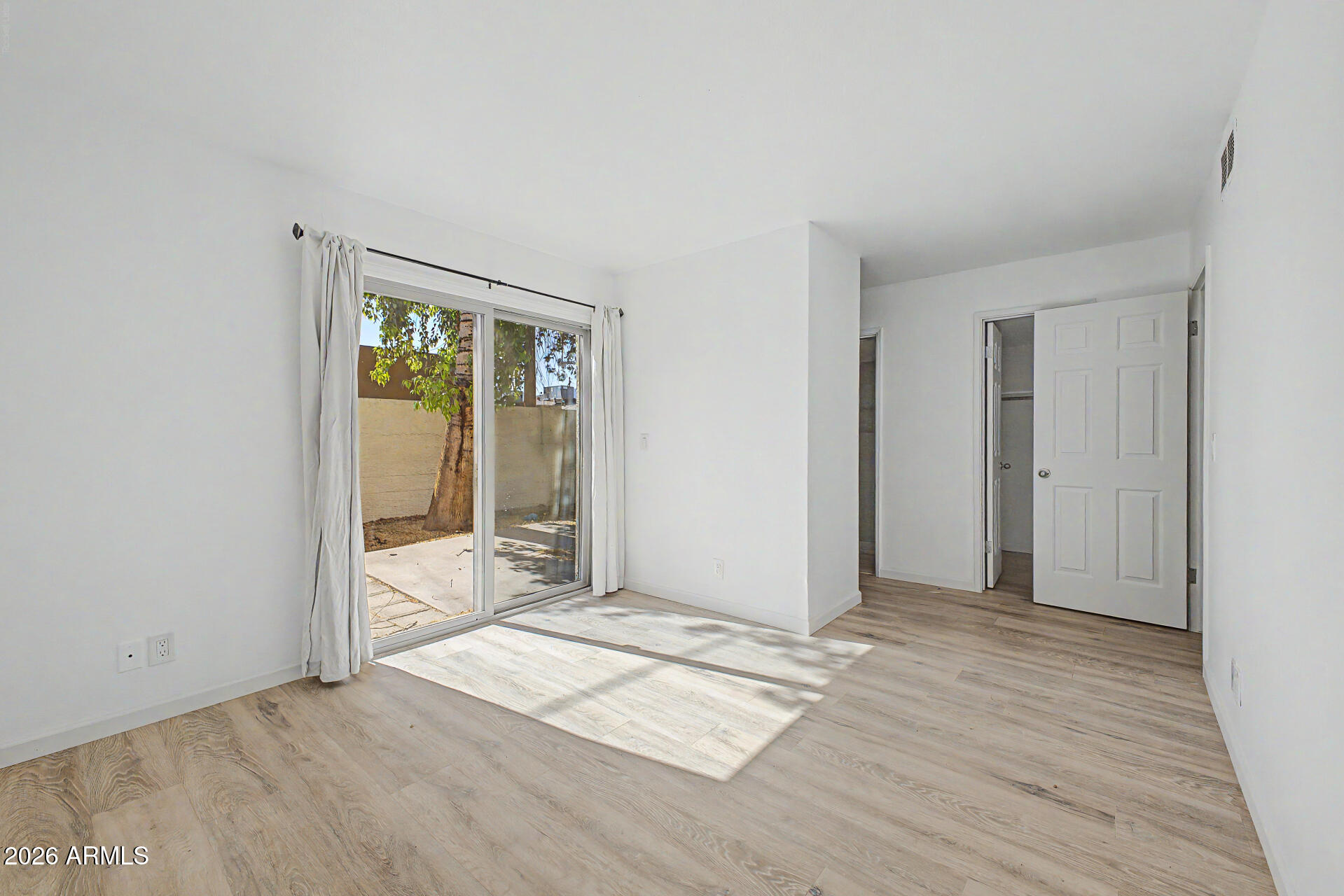 3422 North 12th Place Phoenix, AZ 85014 - Photo 13 of 49 a view of an empty room with wooden floor and a window