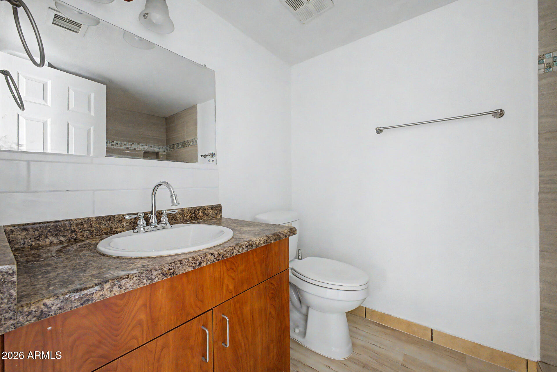 3422 North 12th Place Phoenix, AZ 85014 - Photo 15 of 49 a bathroom with a granite countertop sink a toilet and a mirror