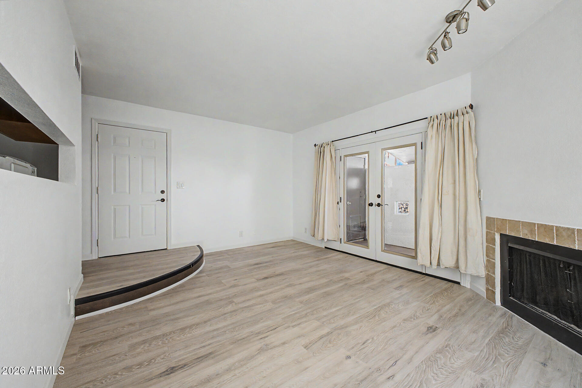 3422 North 12th Place Phoenix, AZ 85014 - Photo 4 of 49 a view of empty room with wooden floor and fan