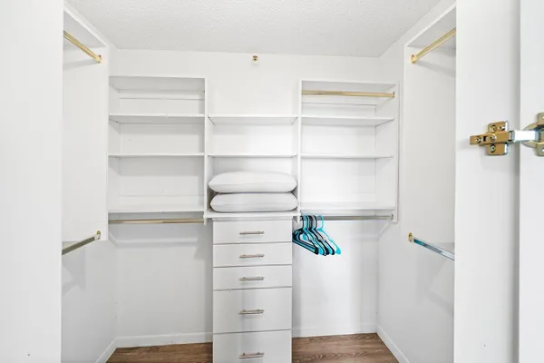 a view of walk in closet with empty racks