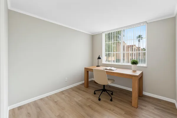 a view of a workspace with furniture and a window