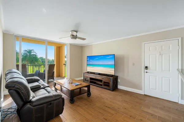 a living room with furniture a ceiling fan and a window