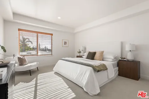 a bedroom with a bed and a large window