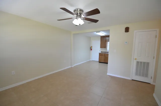 an empty room with closet and a ceiling fan