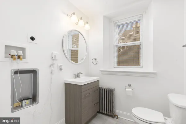 a bathroom with a toilet a sink and mirror