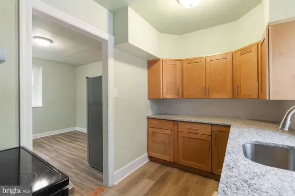 a kitchen with a sink cabinets and wooden floor