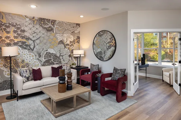 a living room with furniture a clock on wall and a large window