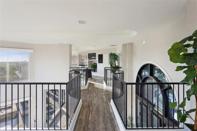 a view of a hardwood & staircase with lots of frames on wall