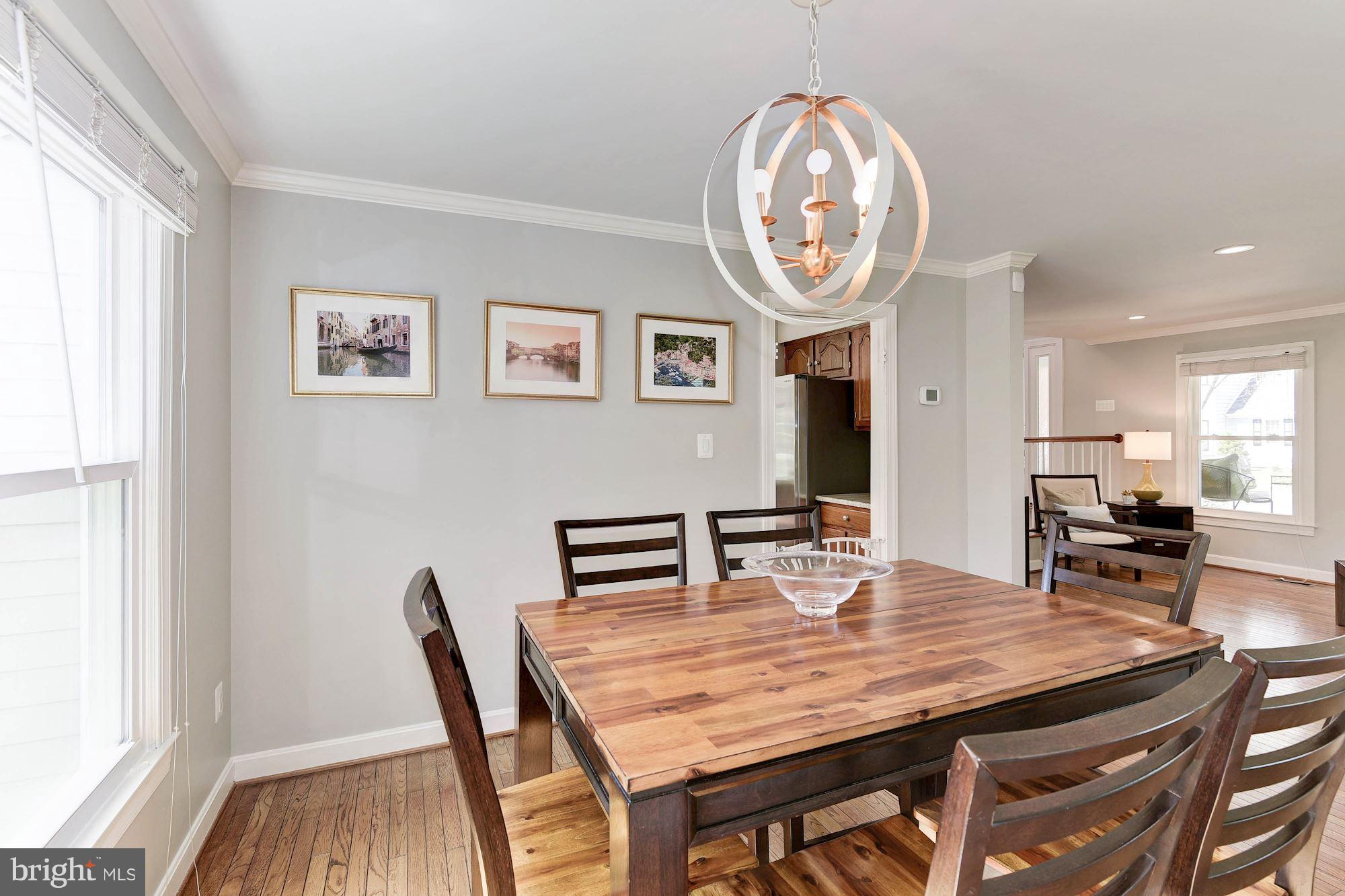 1304 19th Road South Arlington, VA 22202 - Photo 7 of 25 a dining room with wooden floor a large window and a clock
