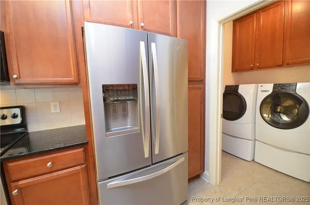 a kitchen with granite countertop a refrigerator and a stove top oven