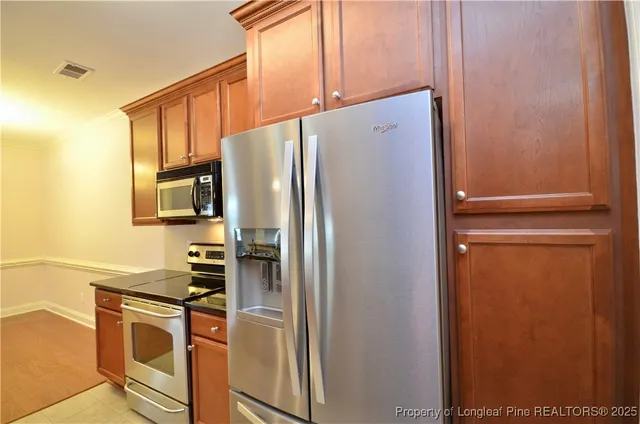 a kitchen with stainless steel appliances a refrigerator and a stove top oven