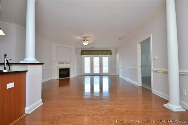 a view of empty room with fireplace and wooden floor