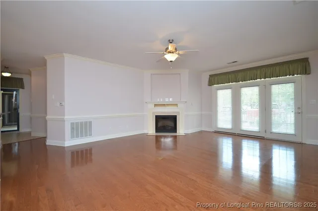 a view of empty room with wooden floor and fireplace