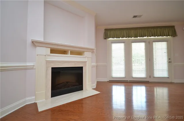 a living room with a fireplace and wooden floor