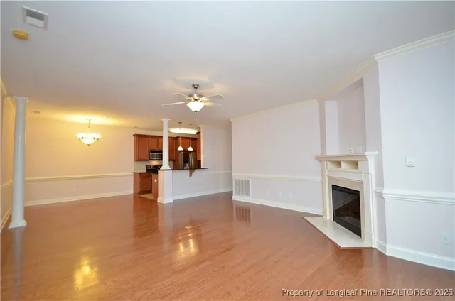 a view of a livingroom with furniture a fireplace and wooden floor