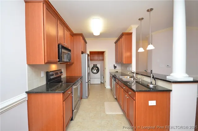 a large kitchen with stainless steel appliances granite countertop a sink a stove and a refrigerator