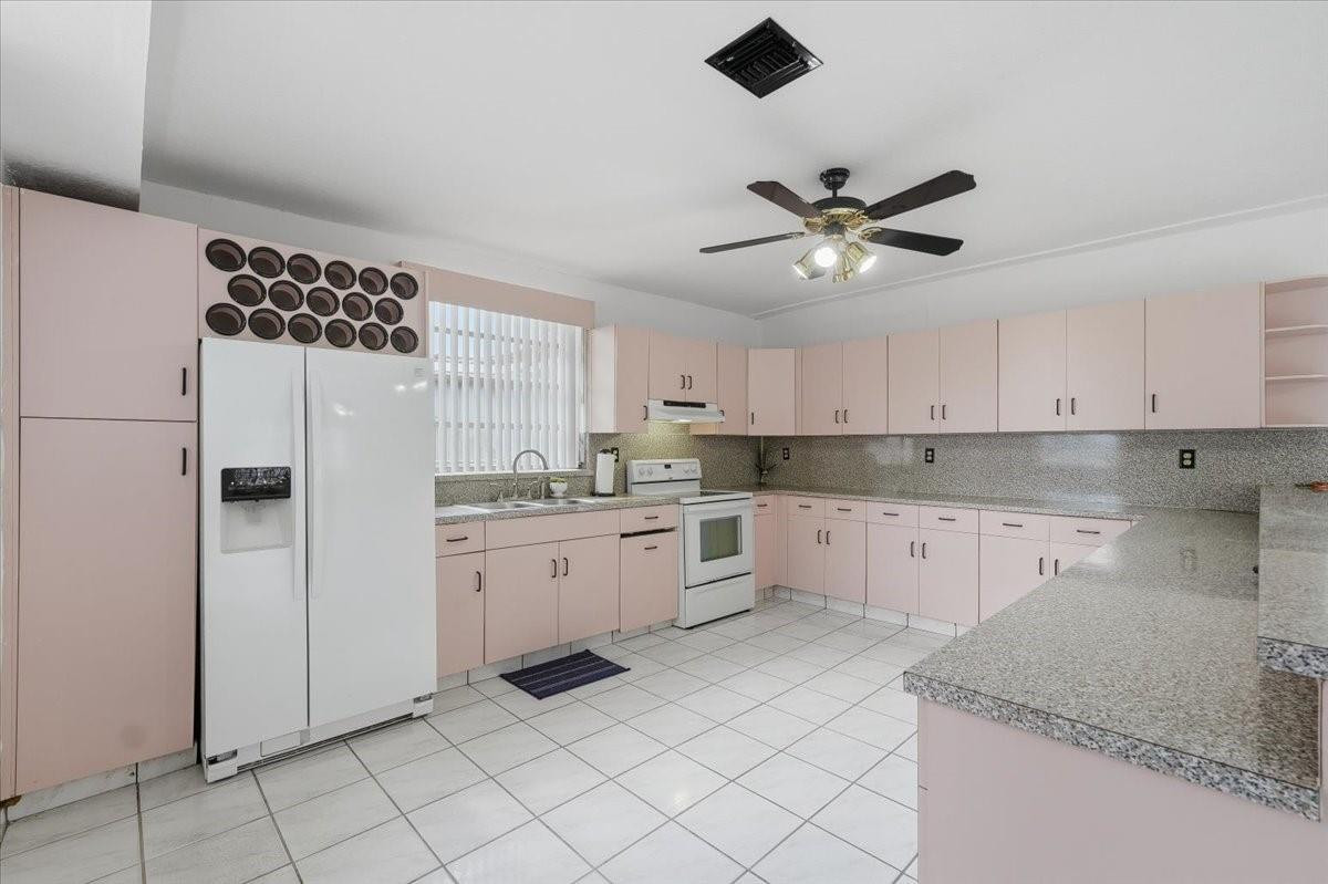 5580 Southwest 2nd Street Miami, FL 33134 - Photo 12 of 29 a kitchen with a white cabinets stove and refrigerator