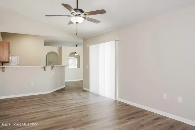a view of a kitchen with wooden floor and a ceiling fan