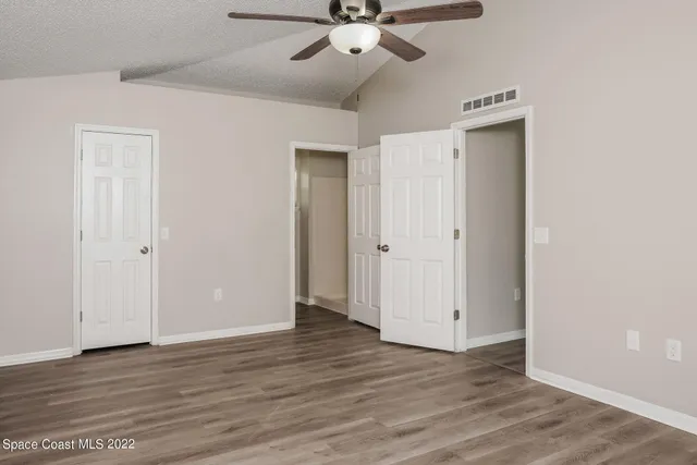 a view of an empty room with wooden floor