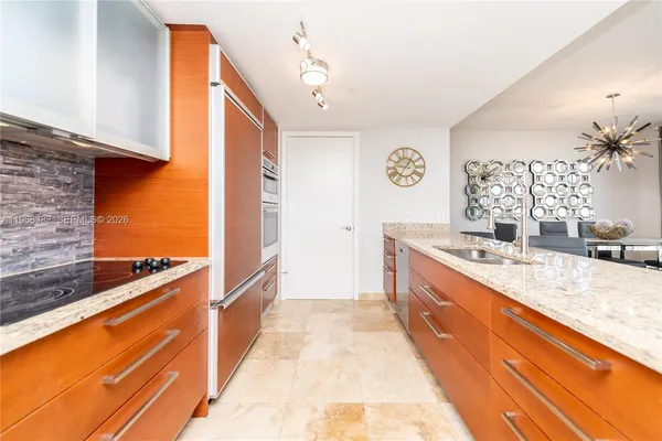 a large kitchen with stainless steel appliances granite countertop a sink and a stove