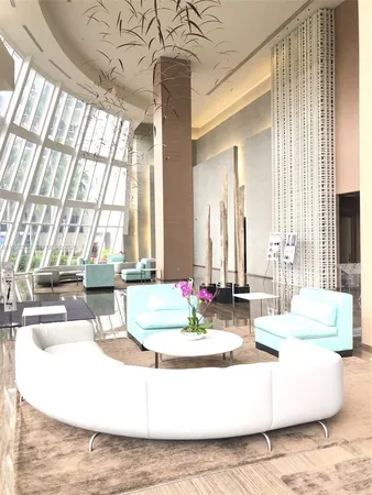 a living room with furniture a large window and a rug