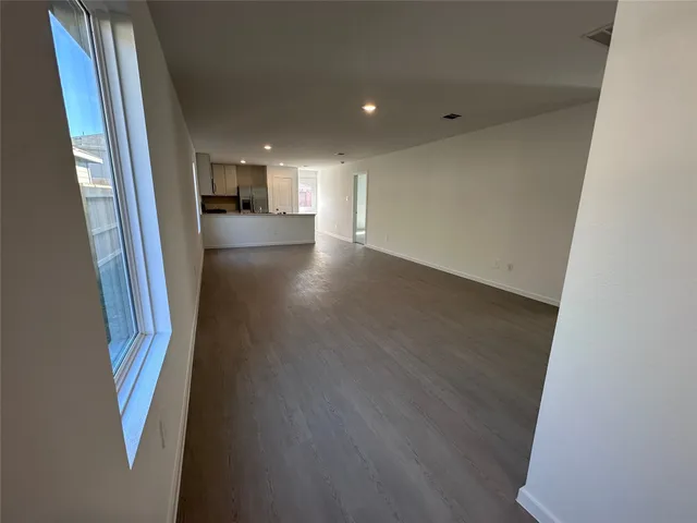 a view of hallway with wooden floor and window