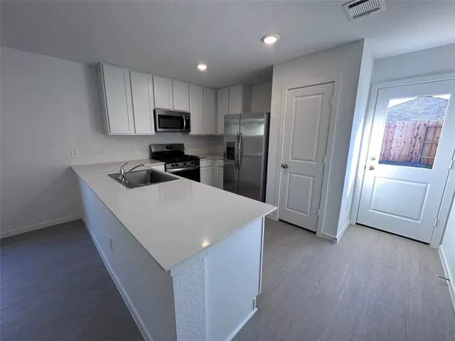 a kitchen with stainless steel appliances a refrigerator sink and microwave