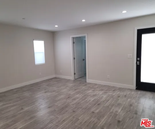 an empty room with wooden floor and window