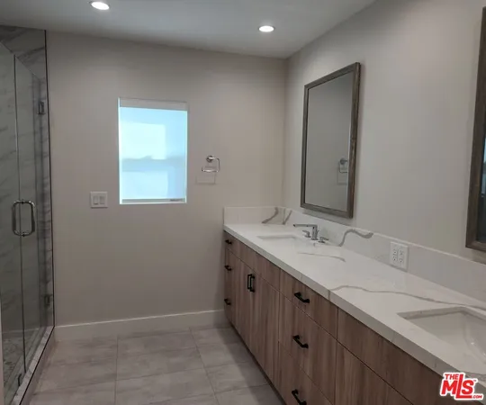 a bathroom with a double vanity sink and a mirror