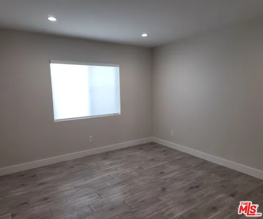 an empty room with wooden floor and a window