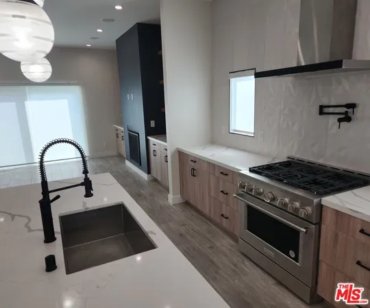 a kitchen with stainless steel appliances kitchen island a stove and a sink
