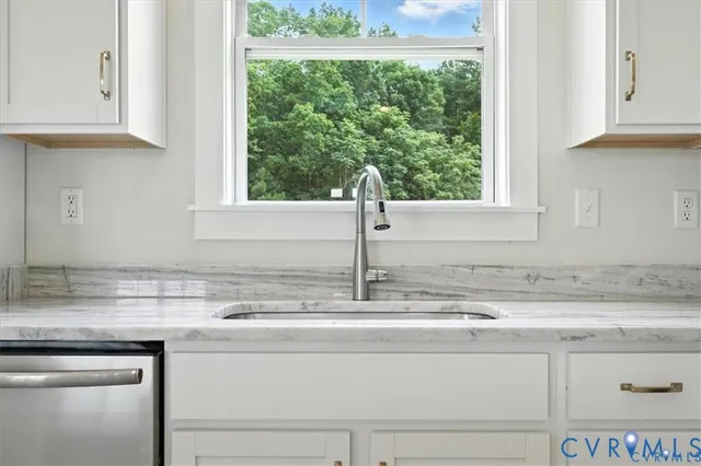 a kitchen with granite countertop white cabinets and stainless steel appliances