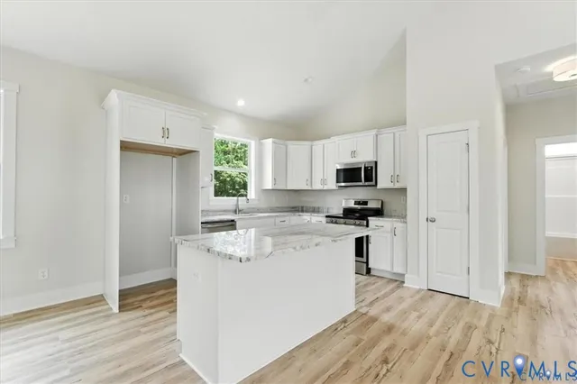 a kitchen with stainless steel appliances granite countertop a stove a sink and a microwave