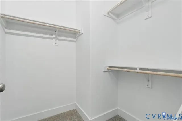 an empty room with windows and chandelier fan