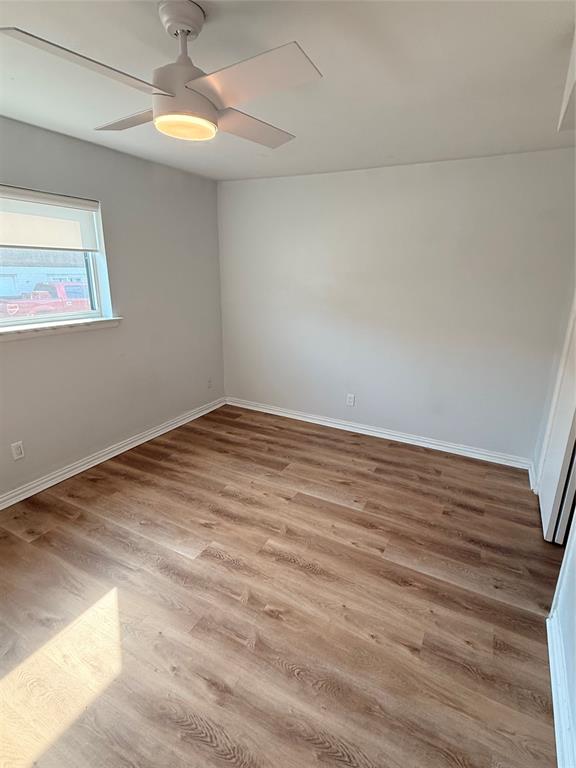 3925 Inwood Road, Unit 1017 Dallas, TX 75209 - Photo 16 of 23 an empty room with wooden floor chandelier fan and windows