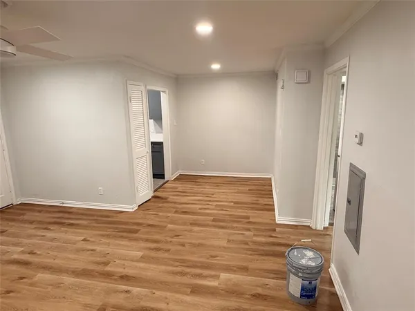 a view of empty room with wooden floor and window