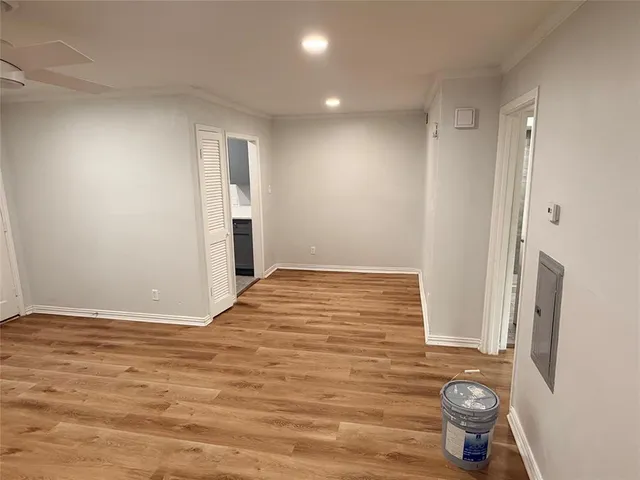 a view of empty room with wooden floor and window