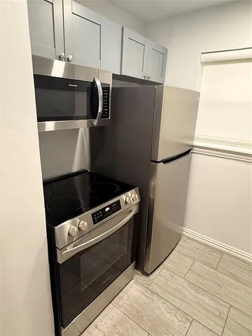 a kitchen with a refrigerator and a stove