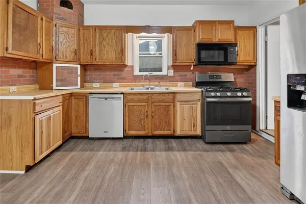 a kitchen with stainless steel appliances granite countertop a stove a sink and a microwave