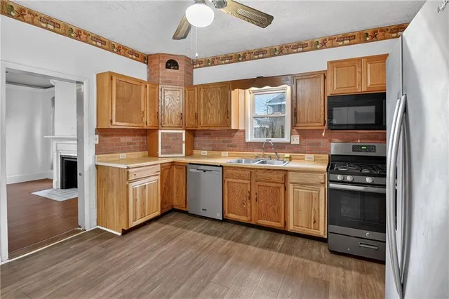 a kitchen with a sink cabinets stainless steel appliances and a window