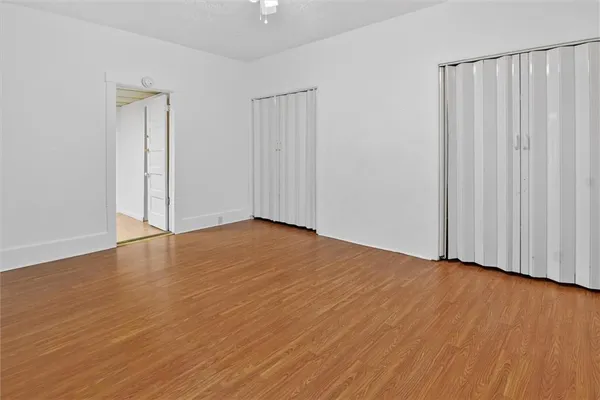 a view of an empty room with wooden floor