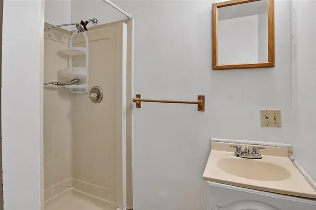 a bathroom with a sink mirror and shower