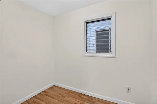 a view of a small space with wooden floor and a window