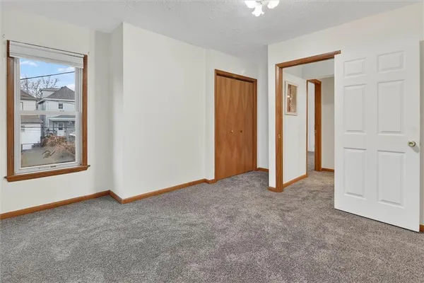 an empty room with windows and closet