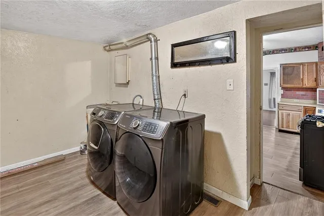 a utility room with wooden floor washer and dryer