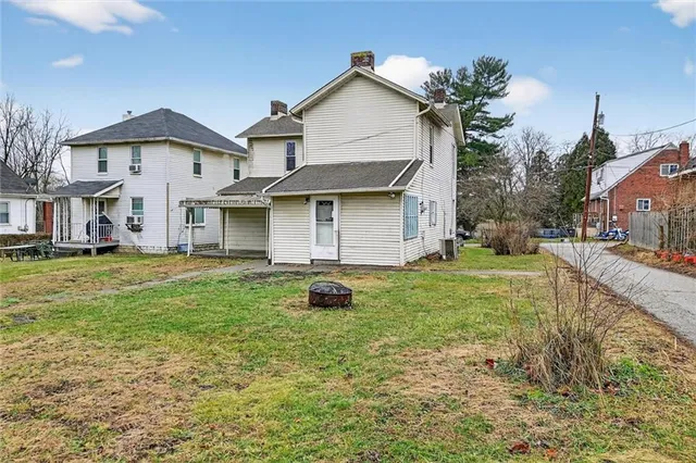 a view of a white house with a yard and large tree