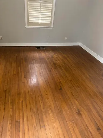 a view of a room with wooden floor and windows