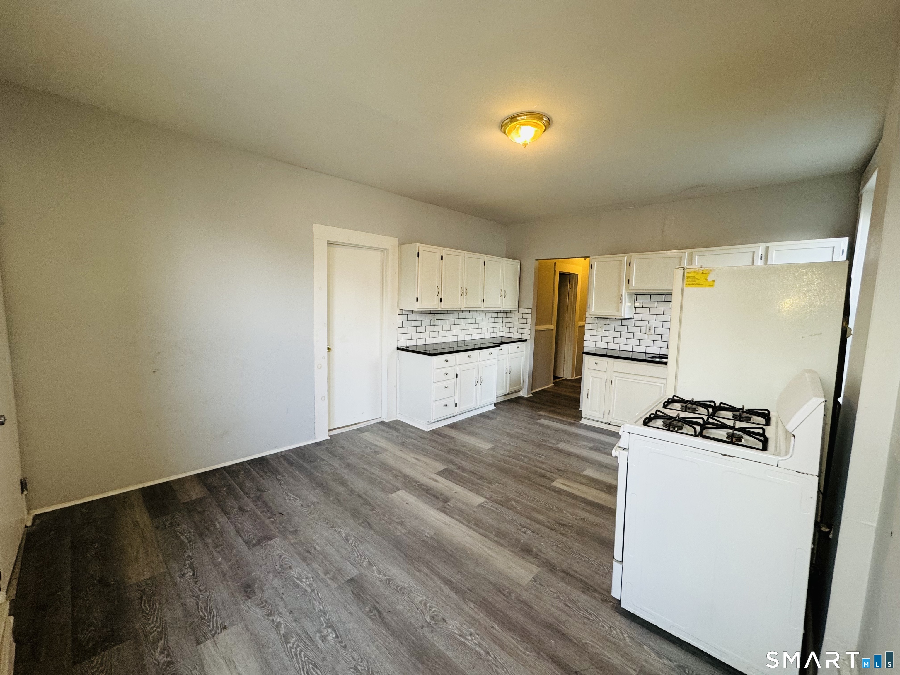 29 White Street, Unit 1 New Haven, CT 06519 - Photo 2 of 11 a kitchen with granite countertop a sink and a stove with wooden floor