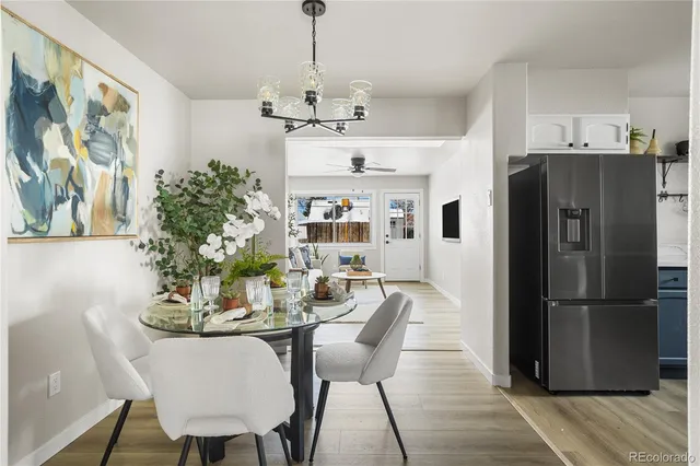 a dining room with furniture a chandelier and wooden floor