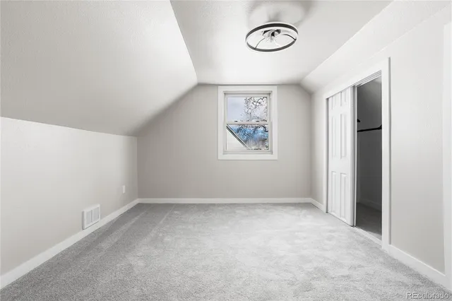 an empty room with a window and a mirror